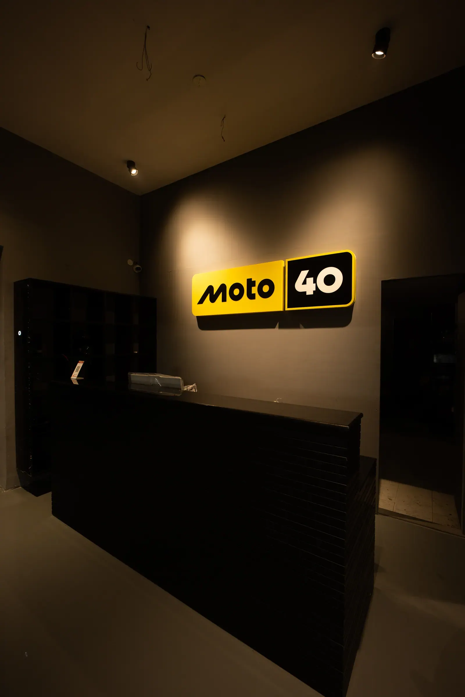 The Moto40 reception desk beneath the illuminated workshop logo