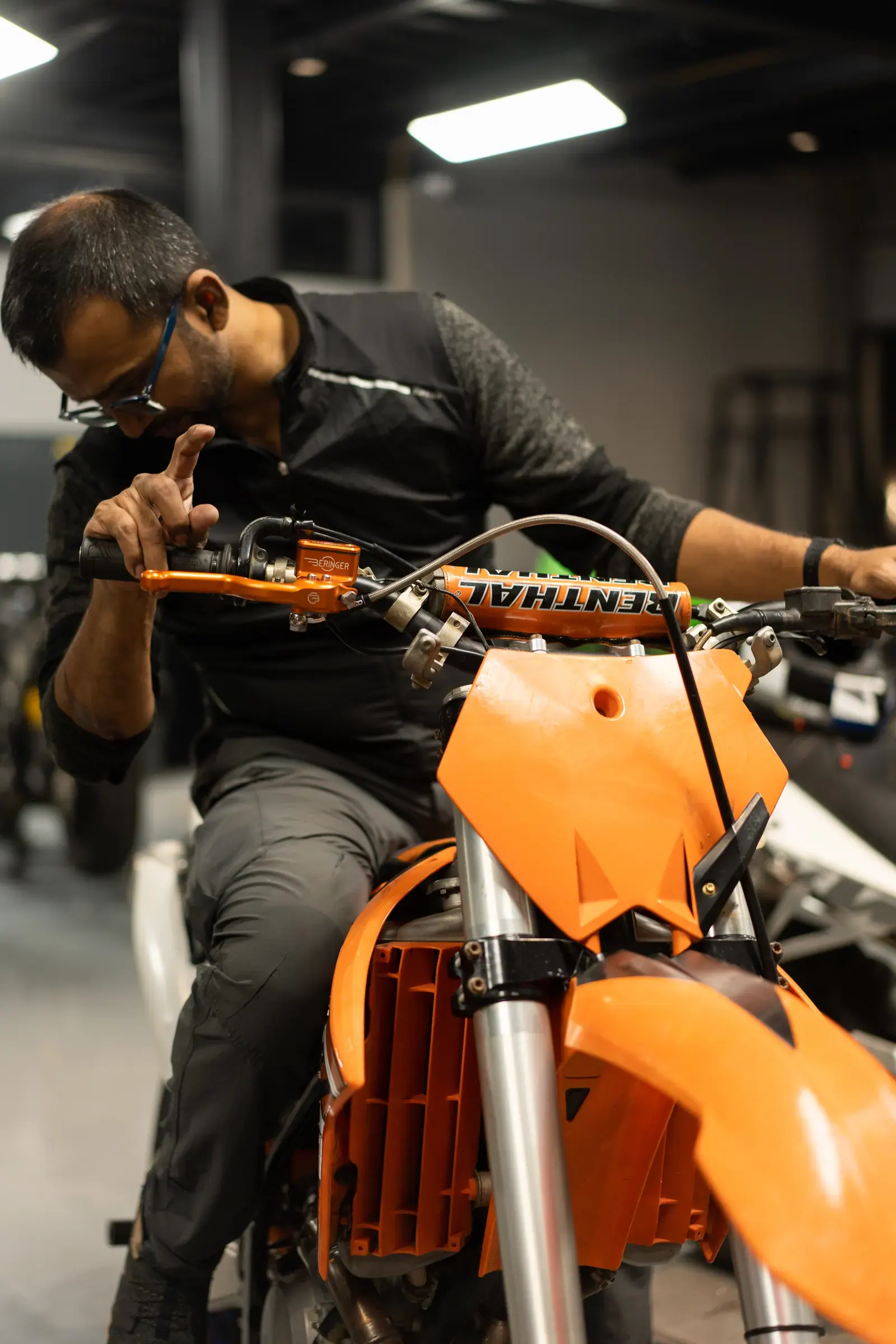 A Moto40 technician working at the handlebars of a motocross bike