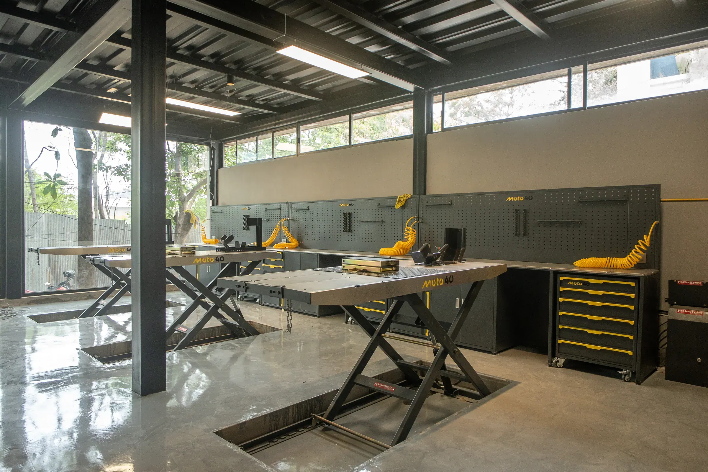 A row of workbenches and lifts along the Moto40 workshop wall
